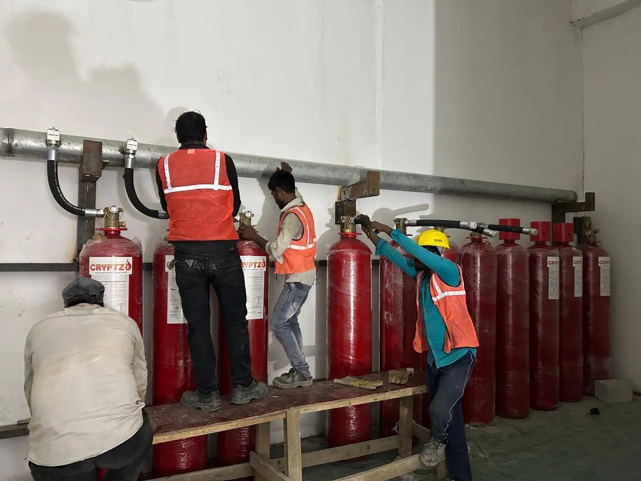 Bank of gas suppression cylinders and discharge manifold being installed at Foxconn