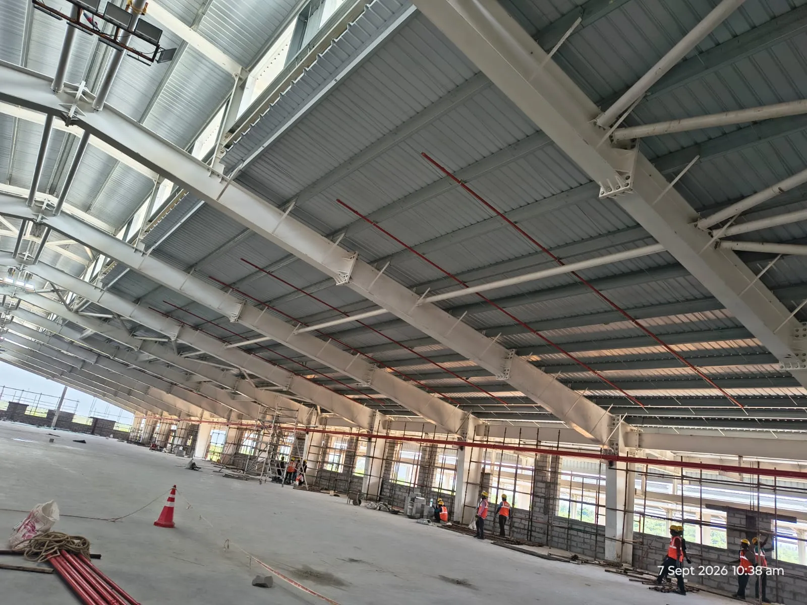 Sprinkler mains running the length of a Pou Chen hall under construction