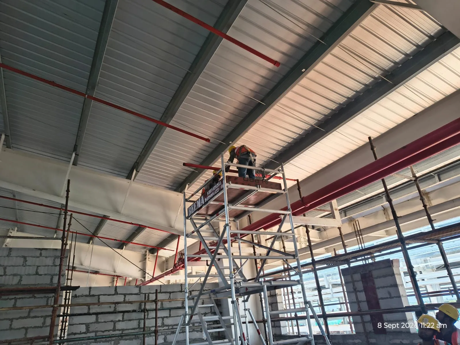 Branch line being fixed to a roof beam from a mobile tower at Pou Chen