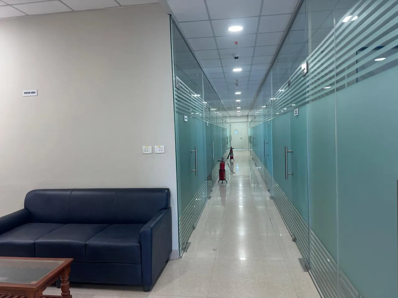 Glazed office corridor with seating and a wall-mounted extinguisher at Kuibyshev Azot