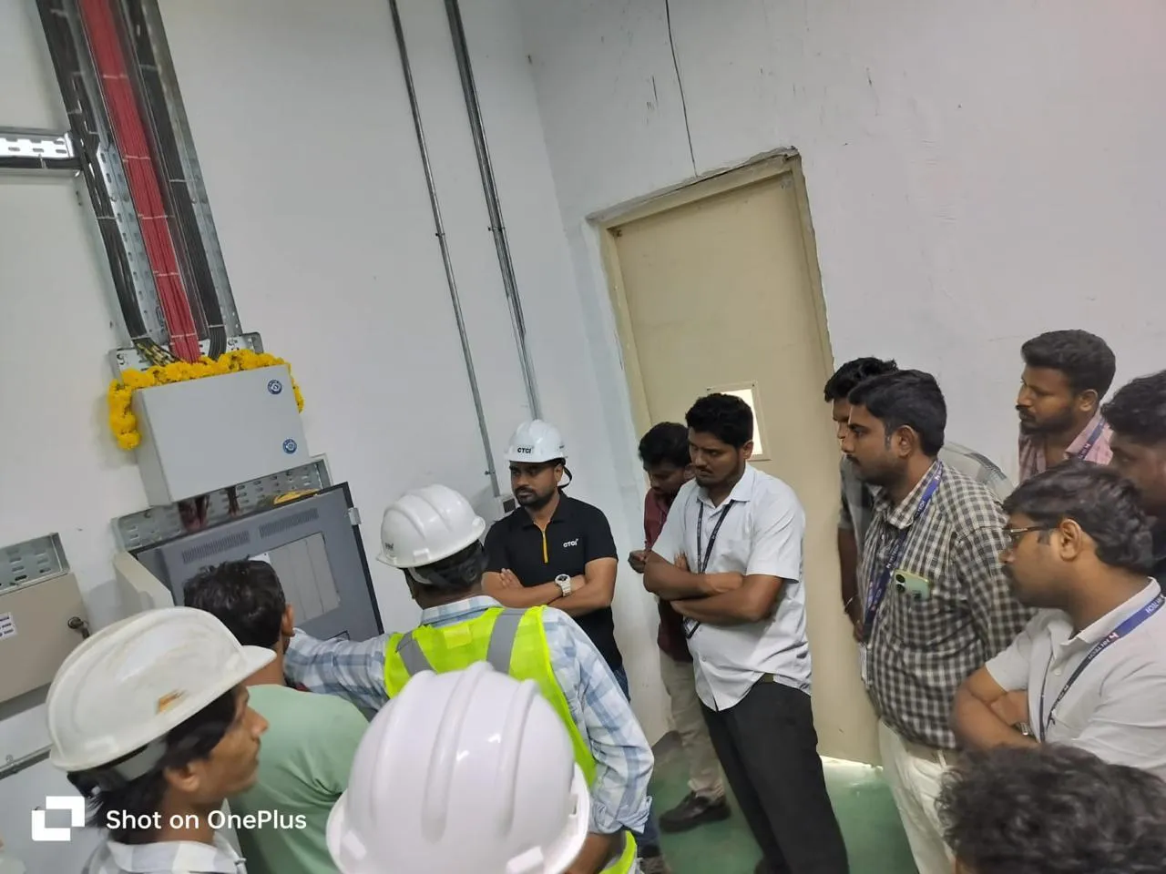 Site team at a wall-mounted control panel during a walkthrough at Foxconn