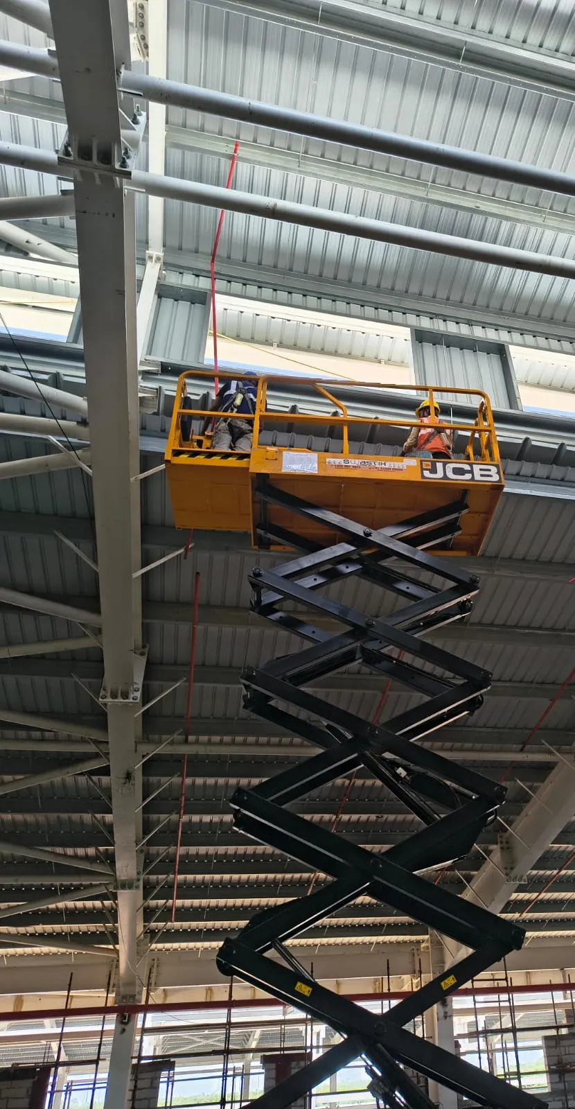 Sprinkler pipework being installed at roof level from a scissor lift at Pou Chen